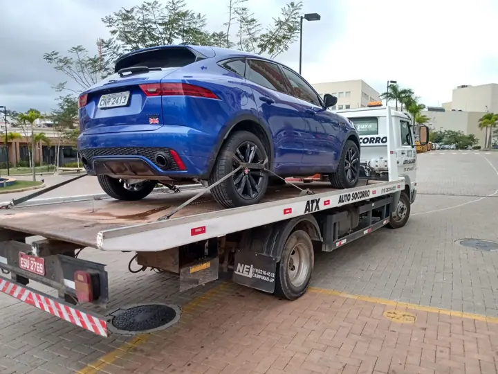 SUV azul transportado na plataforma de um guincho ATX